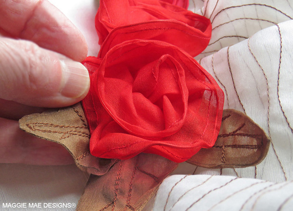 Three red silk organza roses with chocolate silk leaves accent the back of the "Big Brown" hat