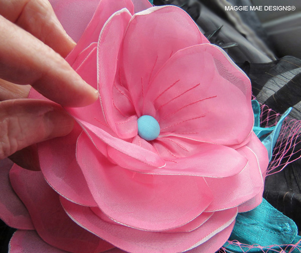 A multi-layered pink silk organza Marguerite is the centerpiece of the "Cozmic One" hat design